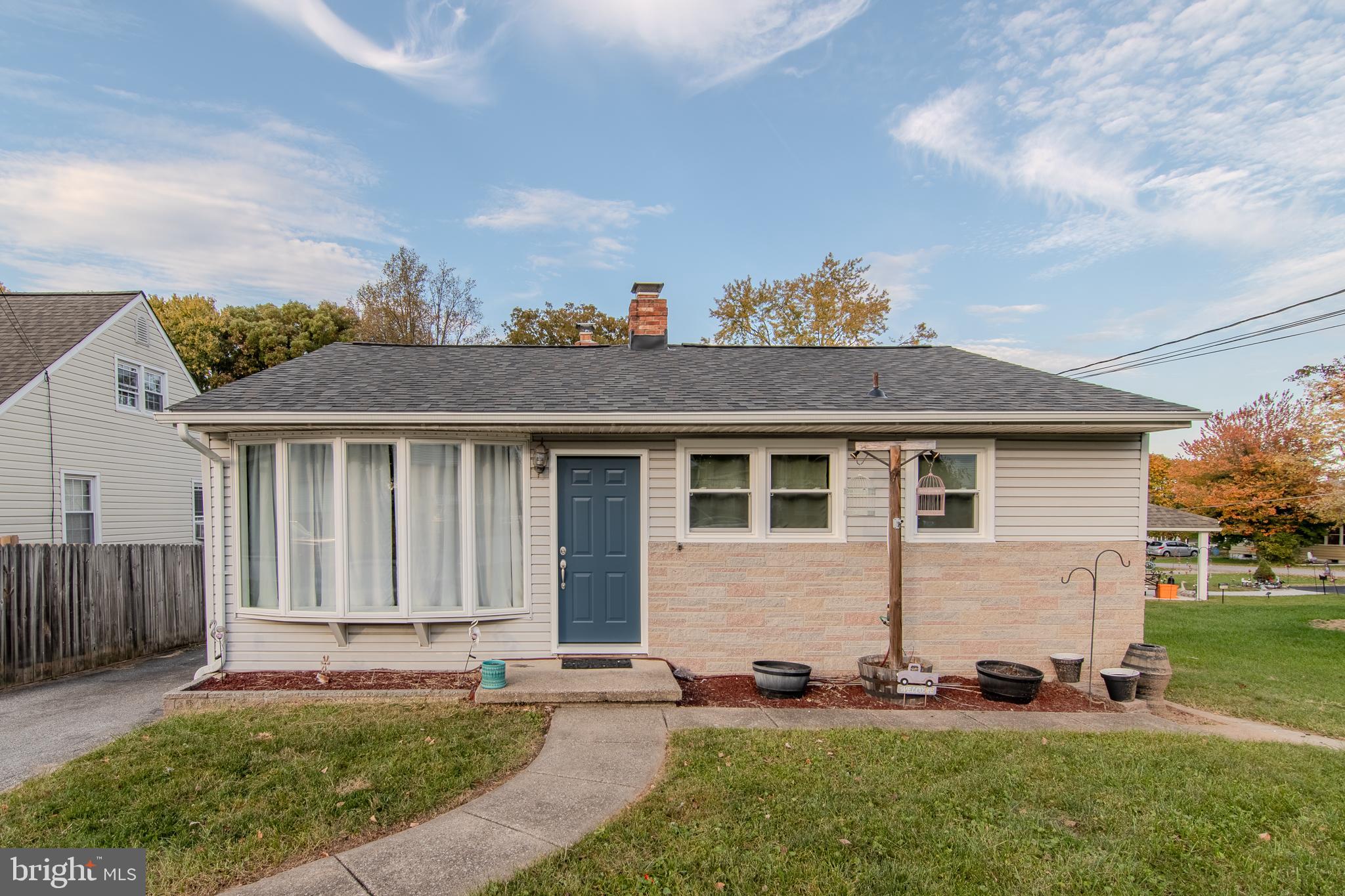 a front view of a house with a yard and outdoor seating