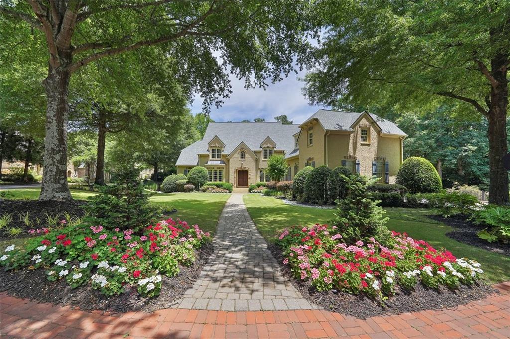 a front view of a house with a big yard and potted plants