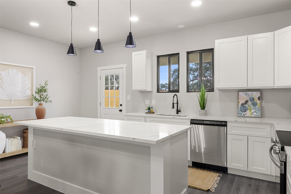 a kitchen with a sink a stove a refrigerator and white cabinets