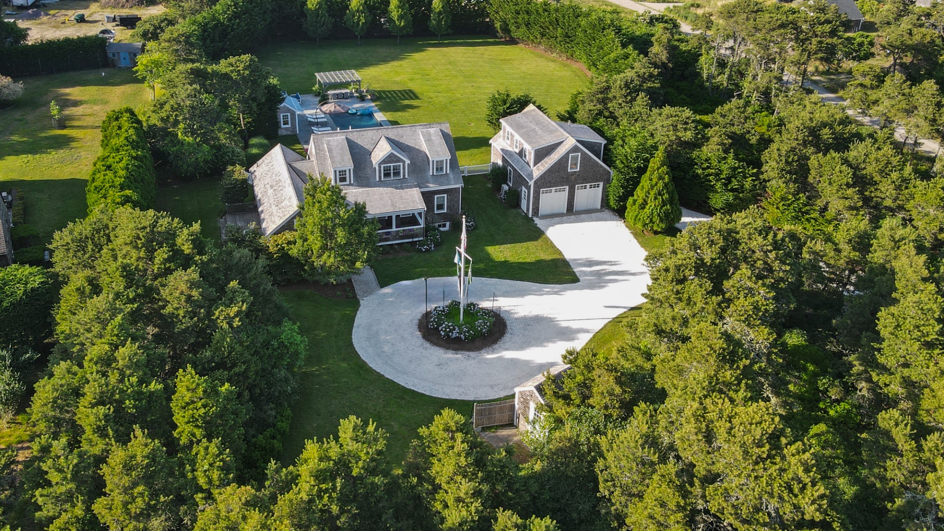 an aerial view of a house with swimming pool and garden