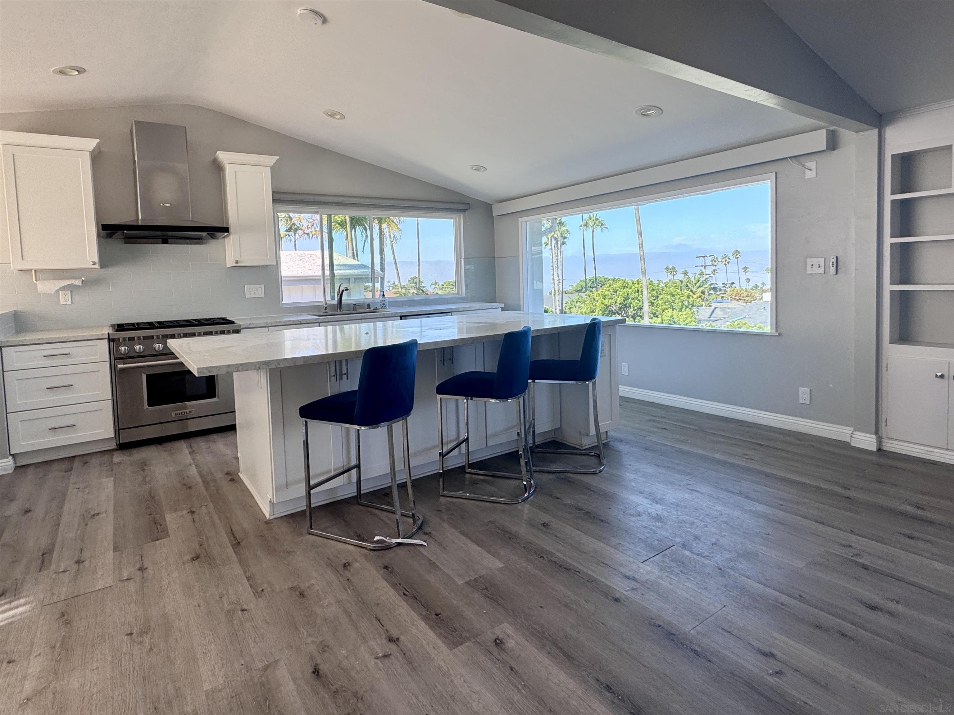 a kitchen with stainless steel appliances granite countertop wooden floors and table