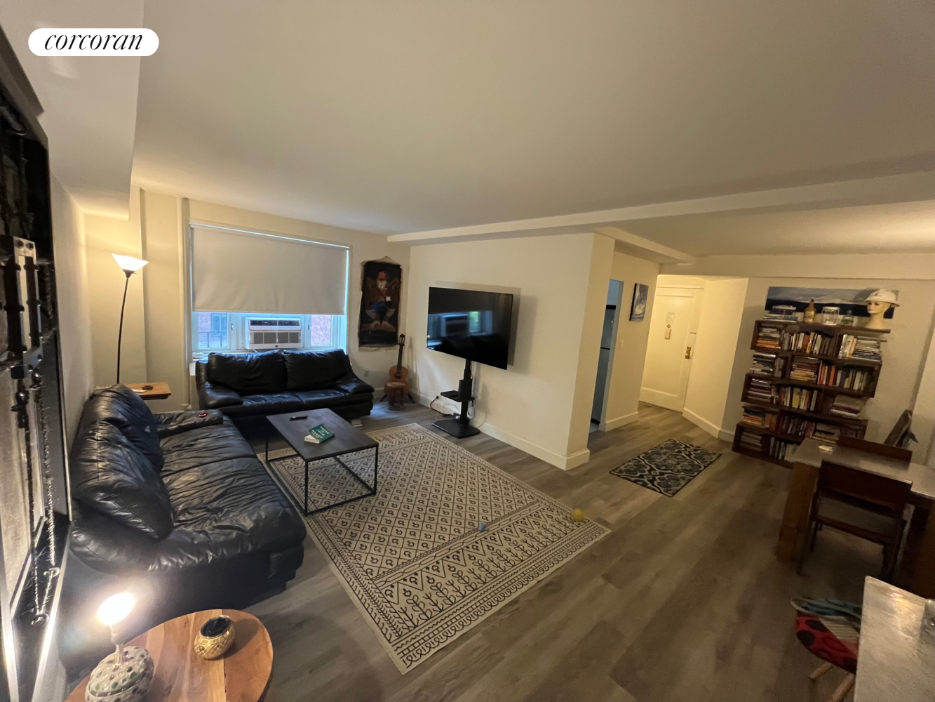 a living room with furniture a window and a flat screen tv