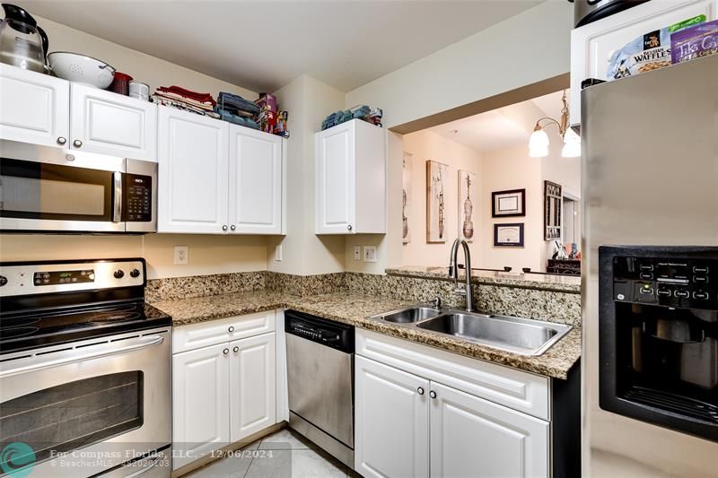 a kitchen with stainless steel appliances granite countertop a sink stove and microwave