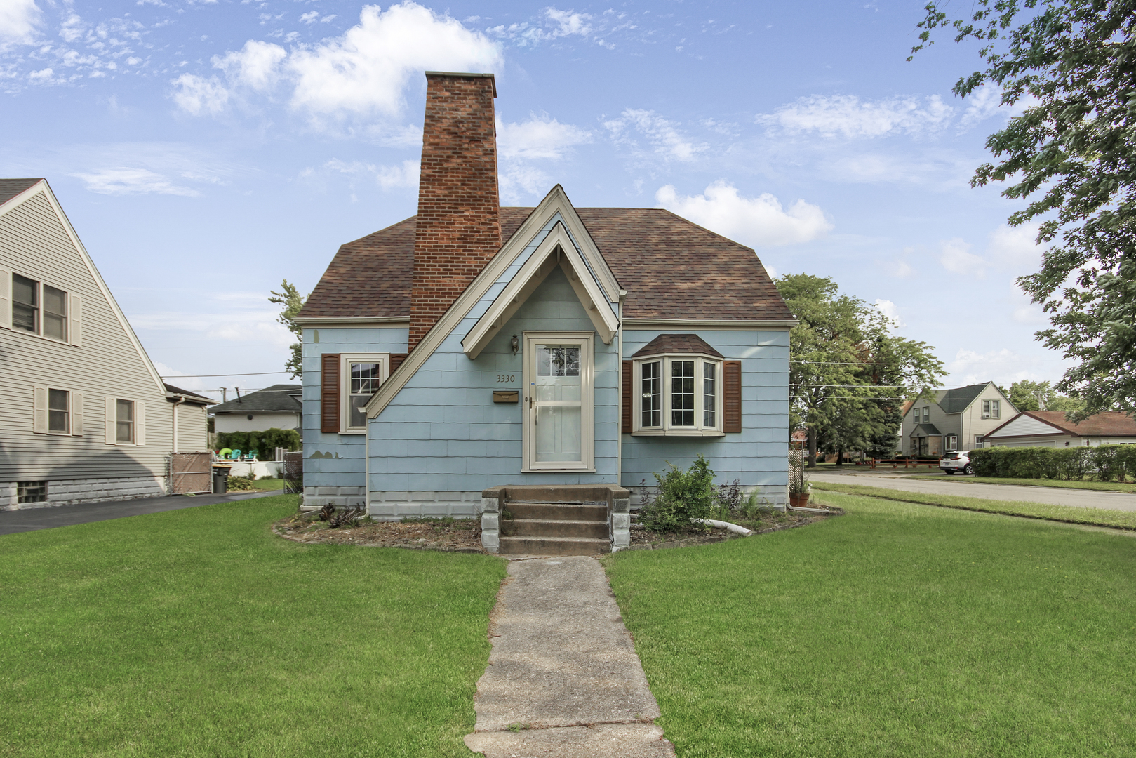 a front view of a house with a garden and yard