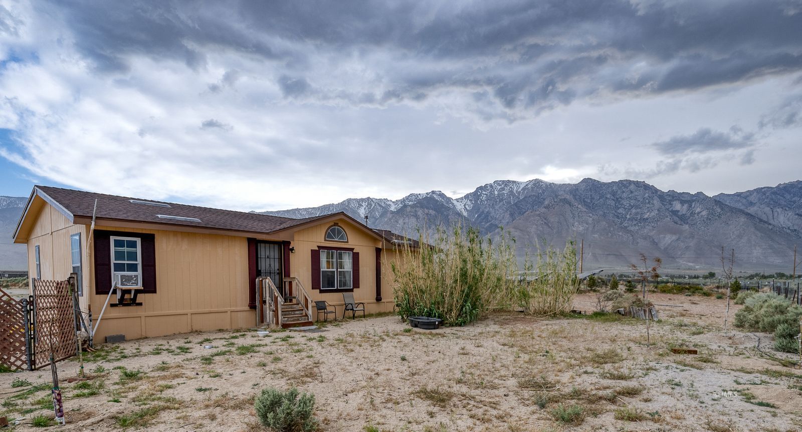 a view of a house with a yard and mountains in the background