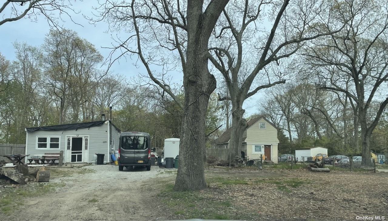 a view of a house with a yard covered in the forest