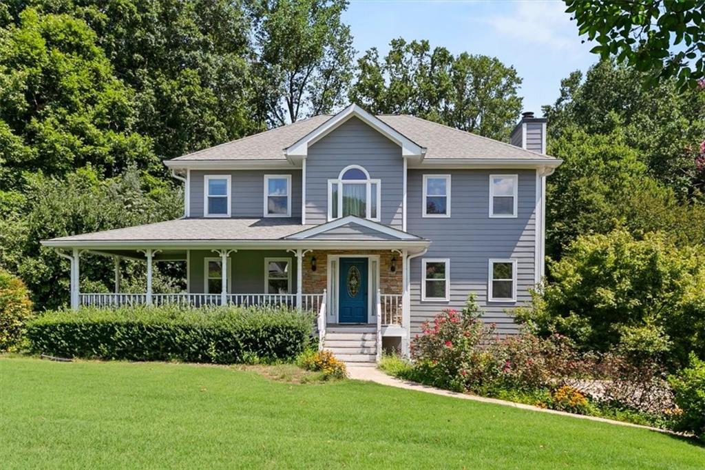 a front view of a house with a yard and green space