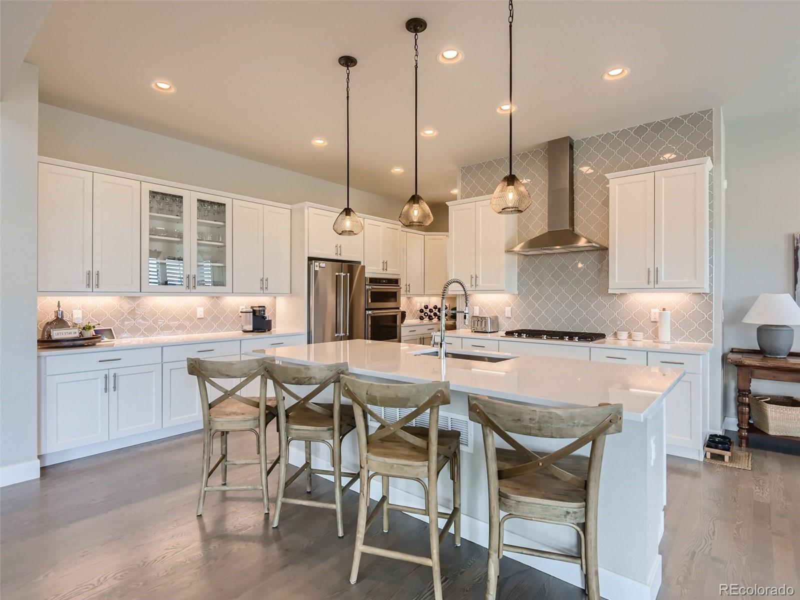 a kitchen with stainless steel appliances kitchen island granite countertop a table chairs sink and cabinets