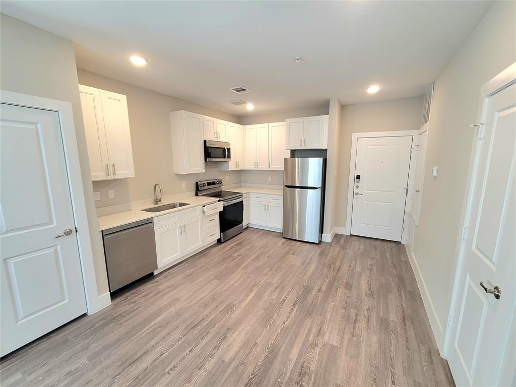 a kitchen with white cabinets and stainless steel appliances