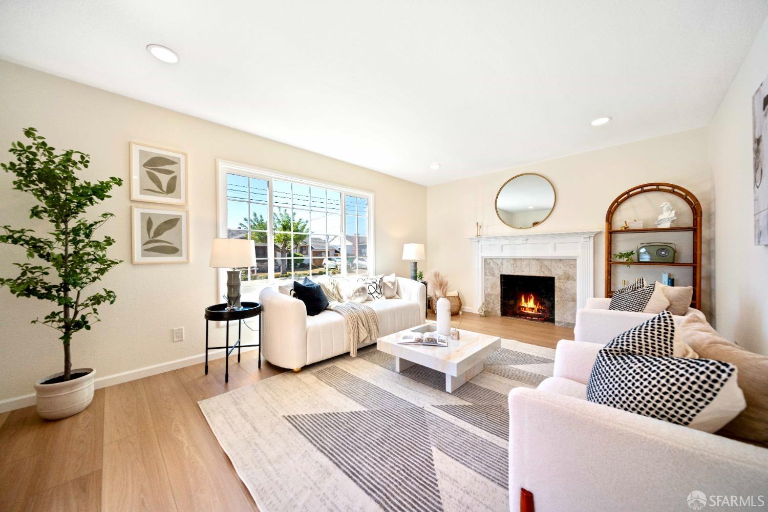 a living room with furniture a fireplace and a potted plant