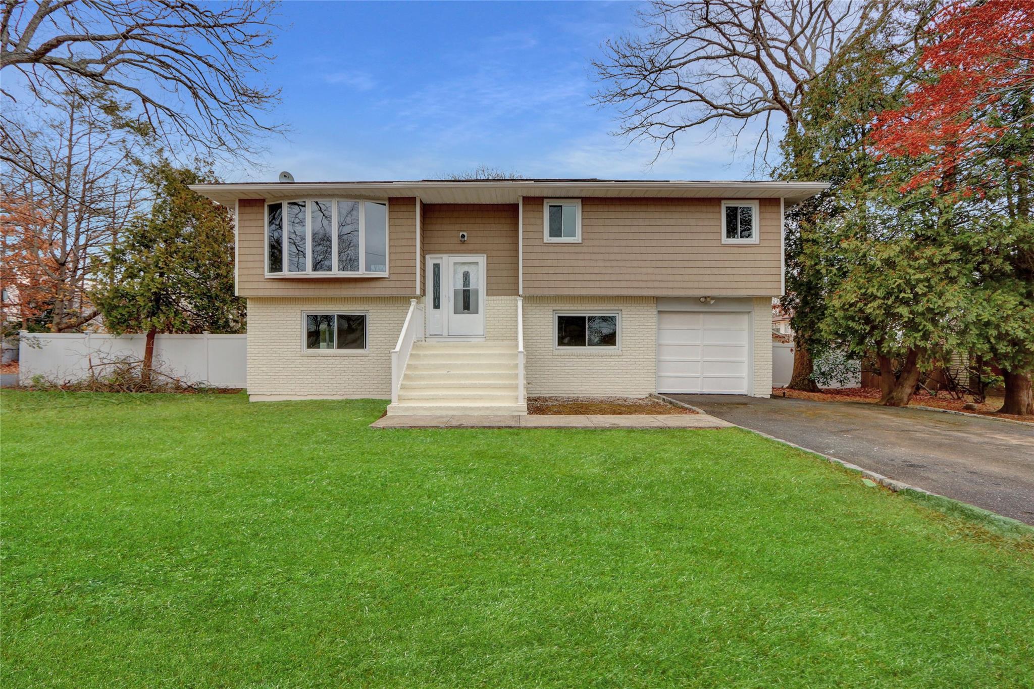 Bi-level home featuring a front lawn and a garage