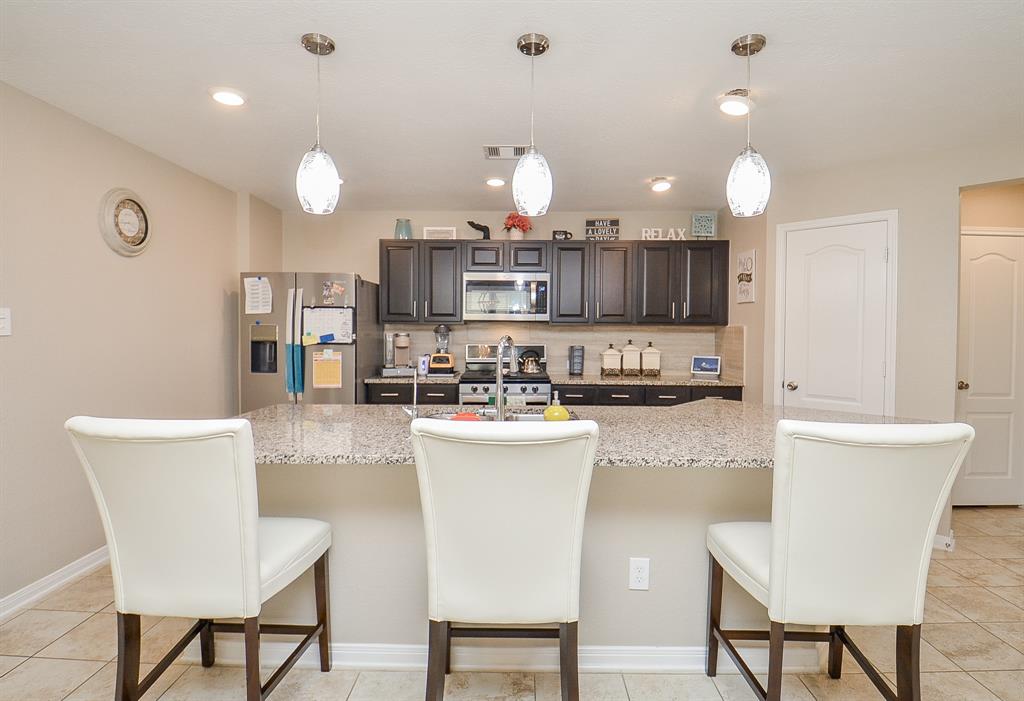 a kitchen with a dining table chairs and refrigerator