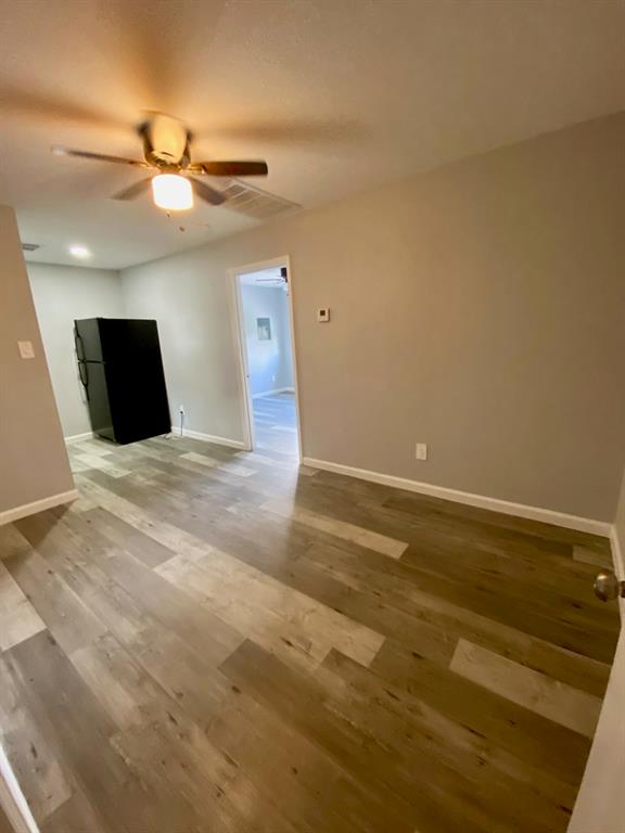 a view of an empty room with a ceiling fan and window