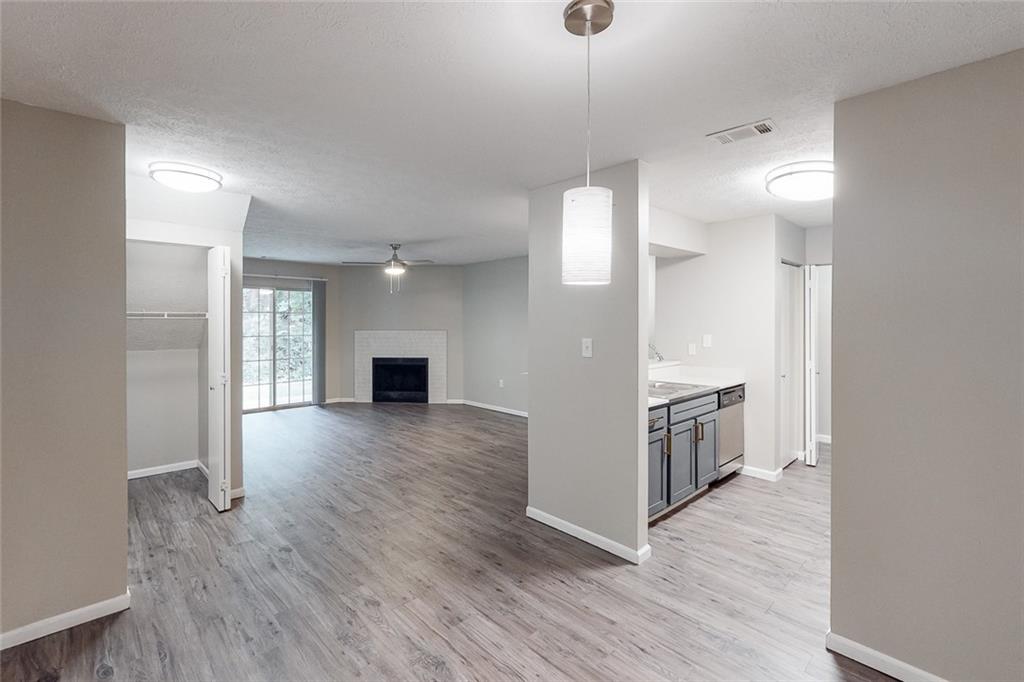 a view of a kitchen an empty room and wooden floor