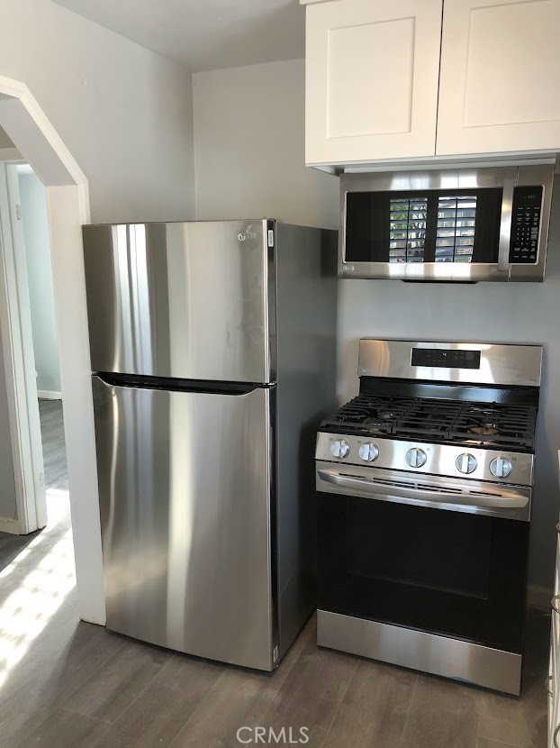 a kitchen with stainless steel appliances granite countertop a refrigerator and a stove top oven