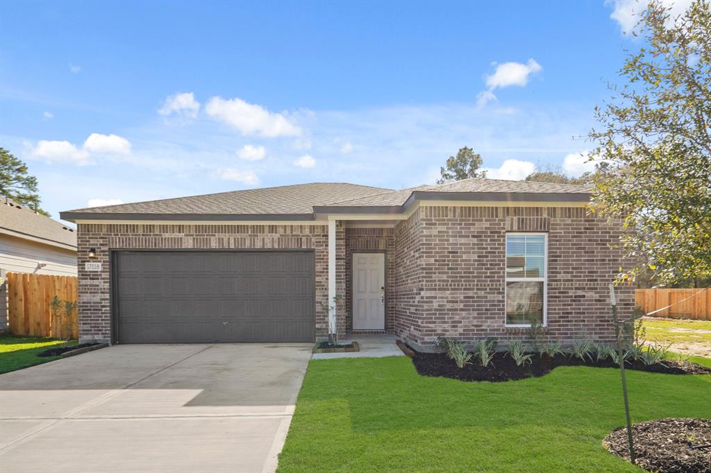 a front view of a house with a garden and yard