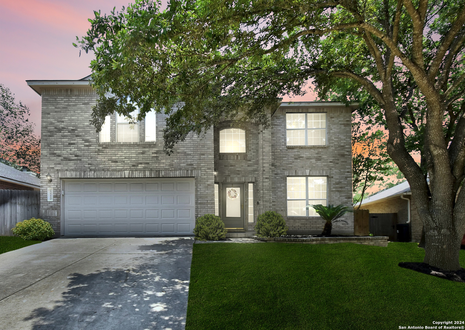 a front view of a house with a garden and trees