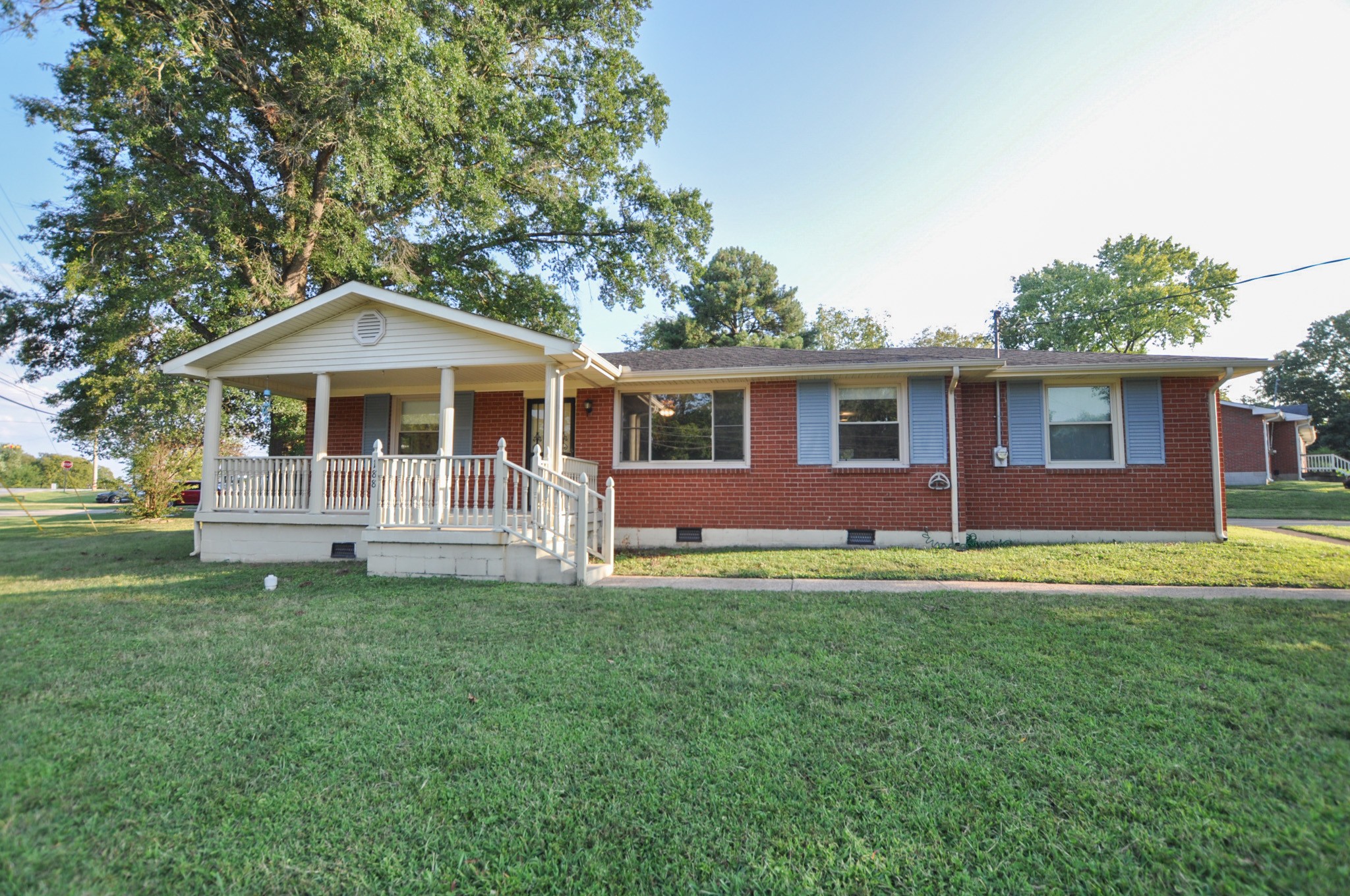 a front view of a house with a yard porch and wooden fence