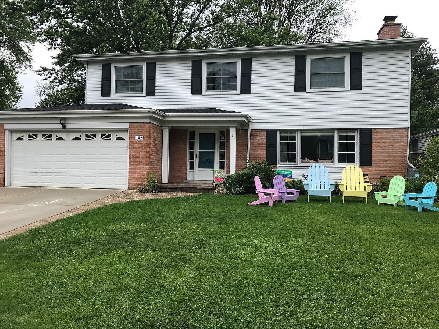 a view of a house with backyard and sitting area