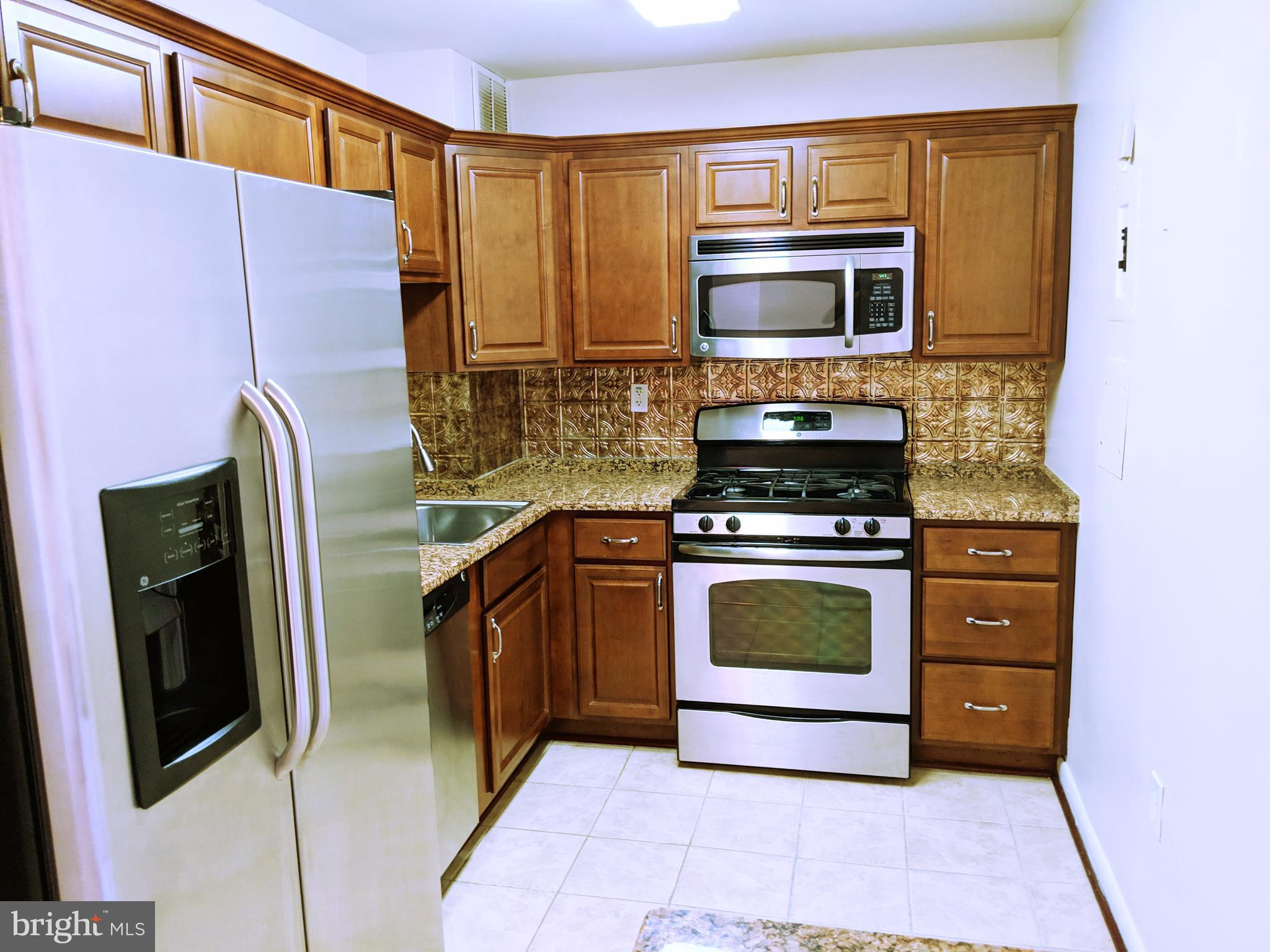 a kitchen with stainless steel appliances a stove microwave and refrigerator