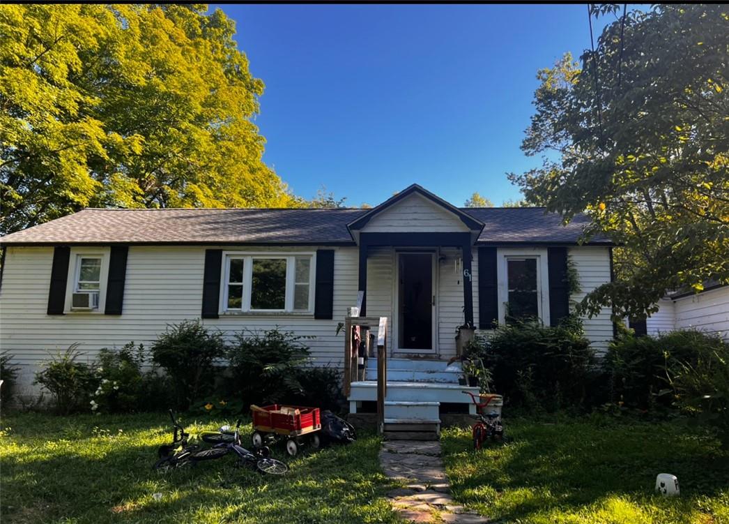 View of front facade featuring cooling unit and a front yard