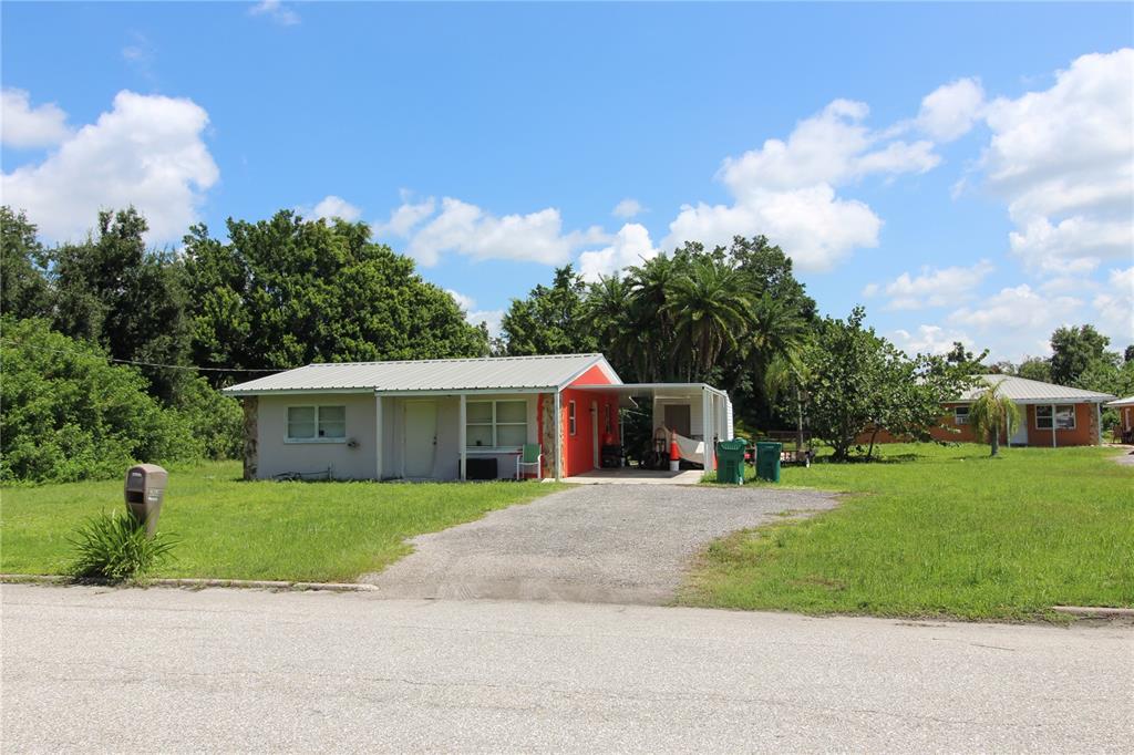 a front view of a house with a yard and trees