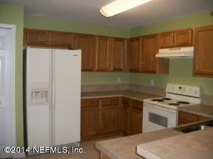 a kitchen with a refrigerator sink and cabinets