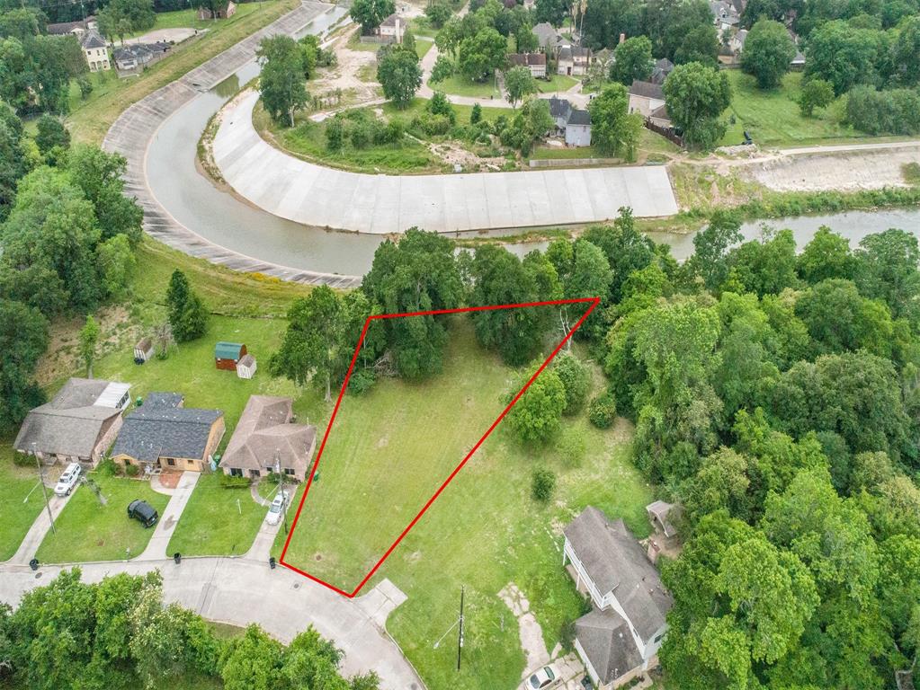 an aerial view of residential house with outdoor space and trees all around