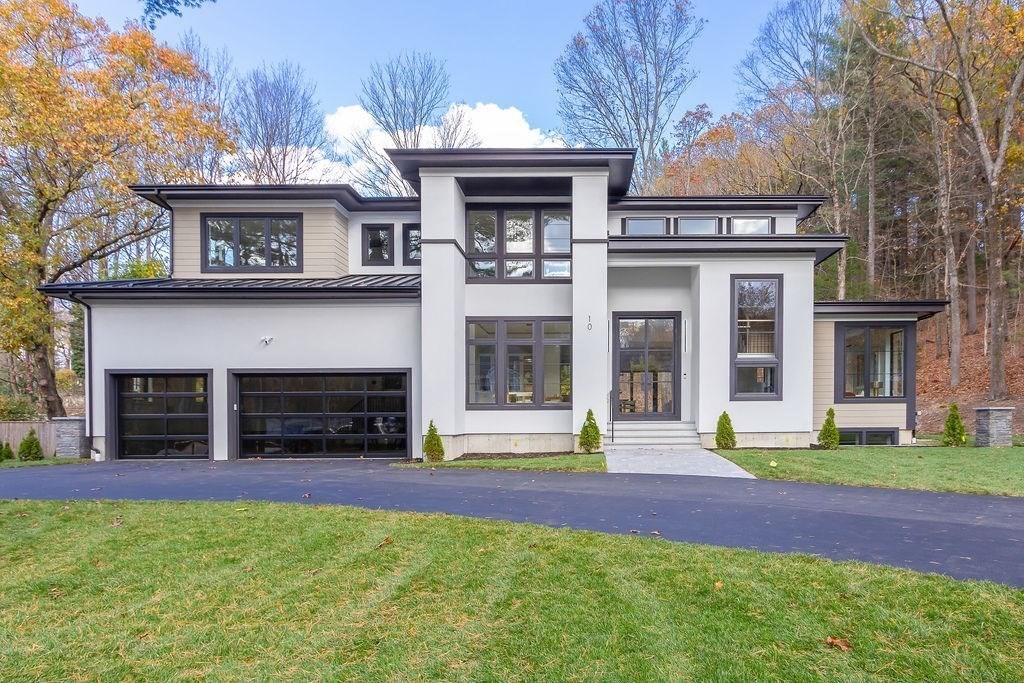 a front view of a house with a lots of plants and garage