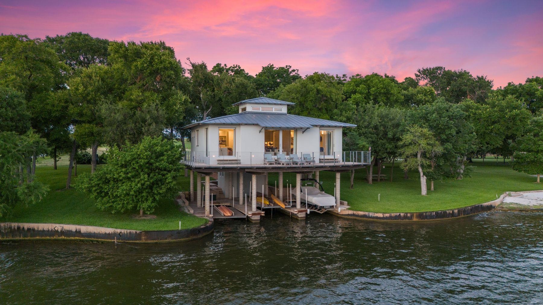 a view of a house with a yard from a lake view