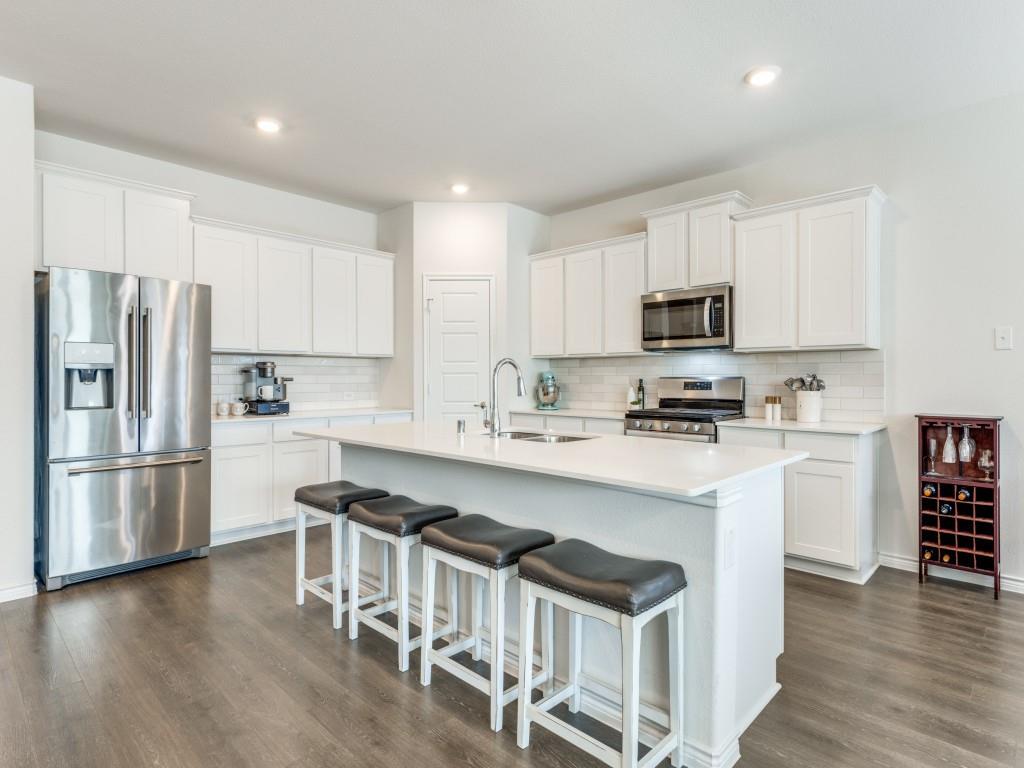 a kitchen with stainless steel appliances a refrigerator stove microwave and cabinets