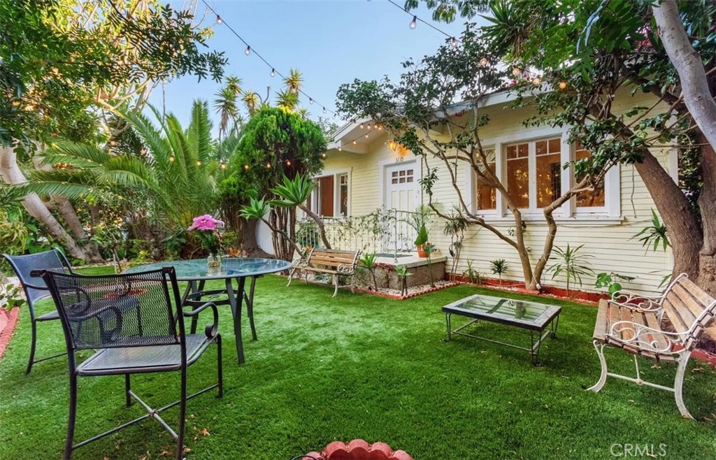 a view of a backyard with table and chairs and a fire pit