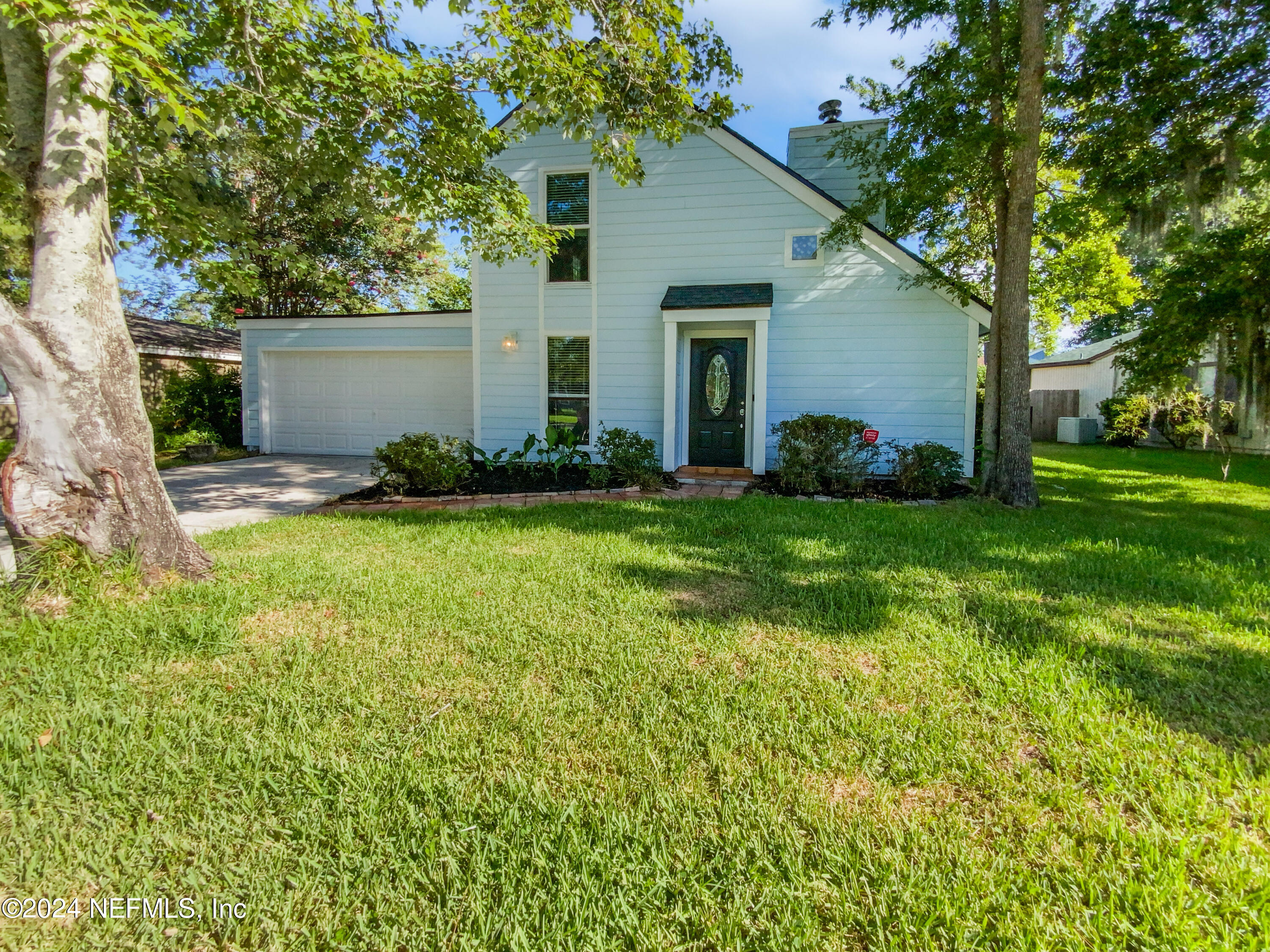 a view of a house with a yard and tree