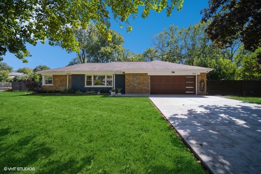 a front view of a house with a yard and trees