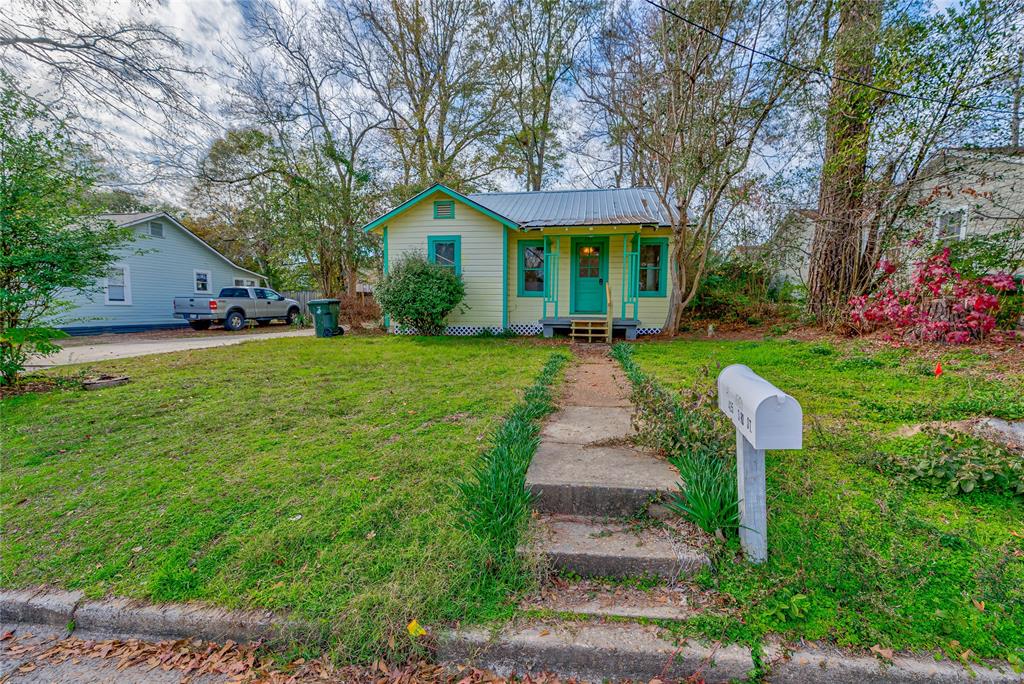 a front view of a house with a yard and trees