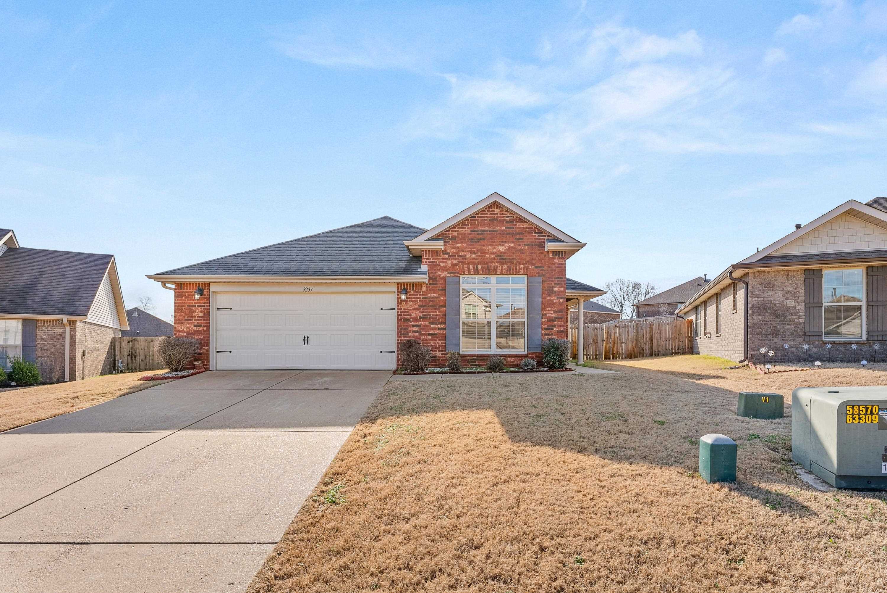 View of front of house with a garage and a front lawn