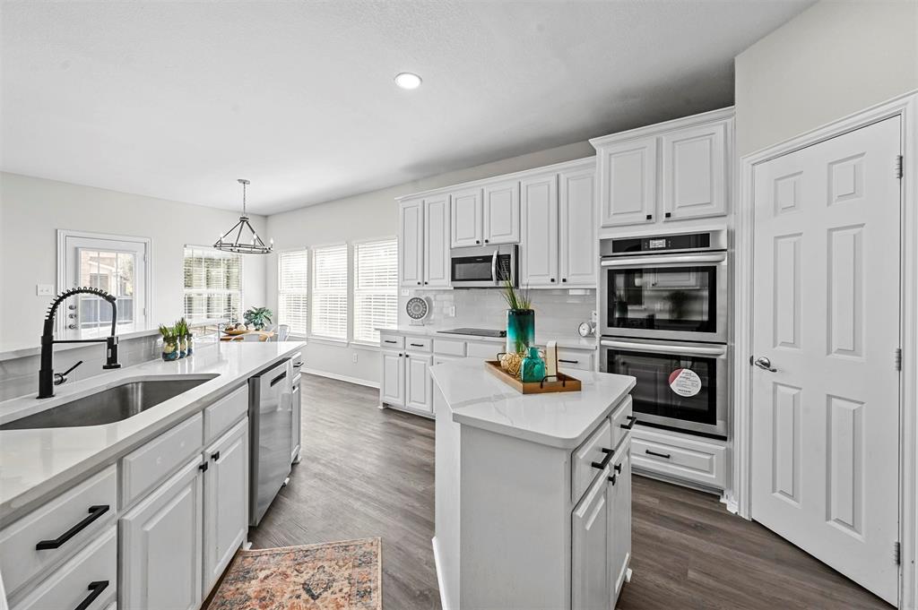 a kitchen with white cabinets and appliances