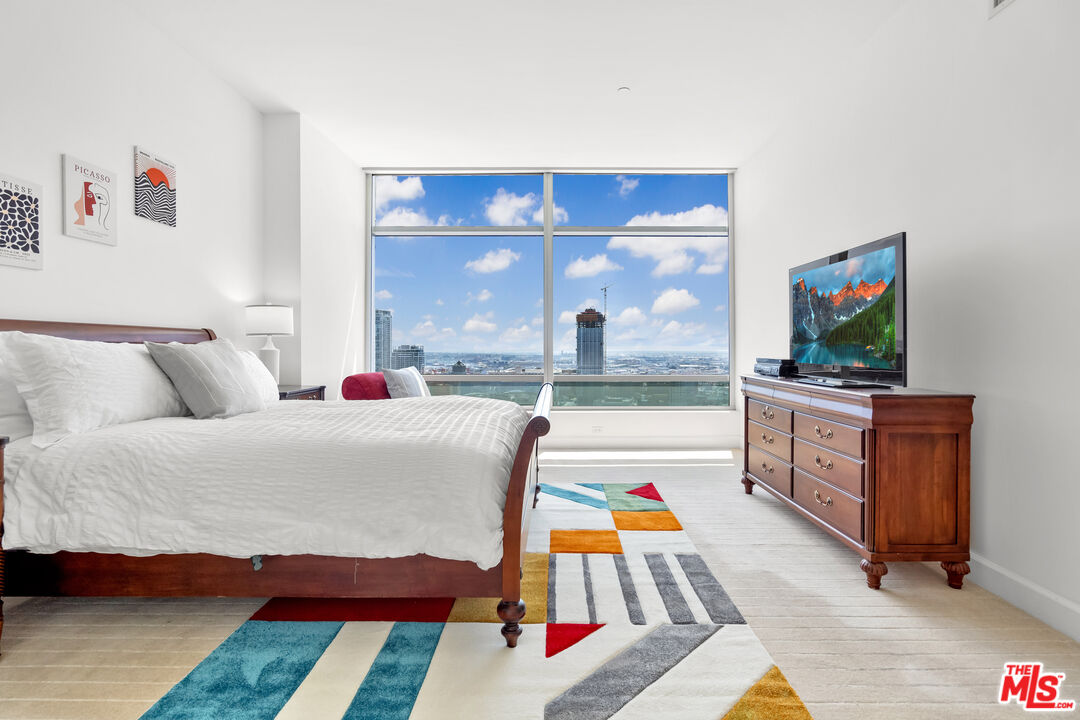 a bedroom with furniture and a flat screen tv