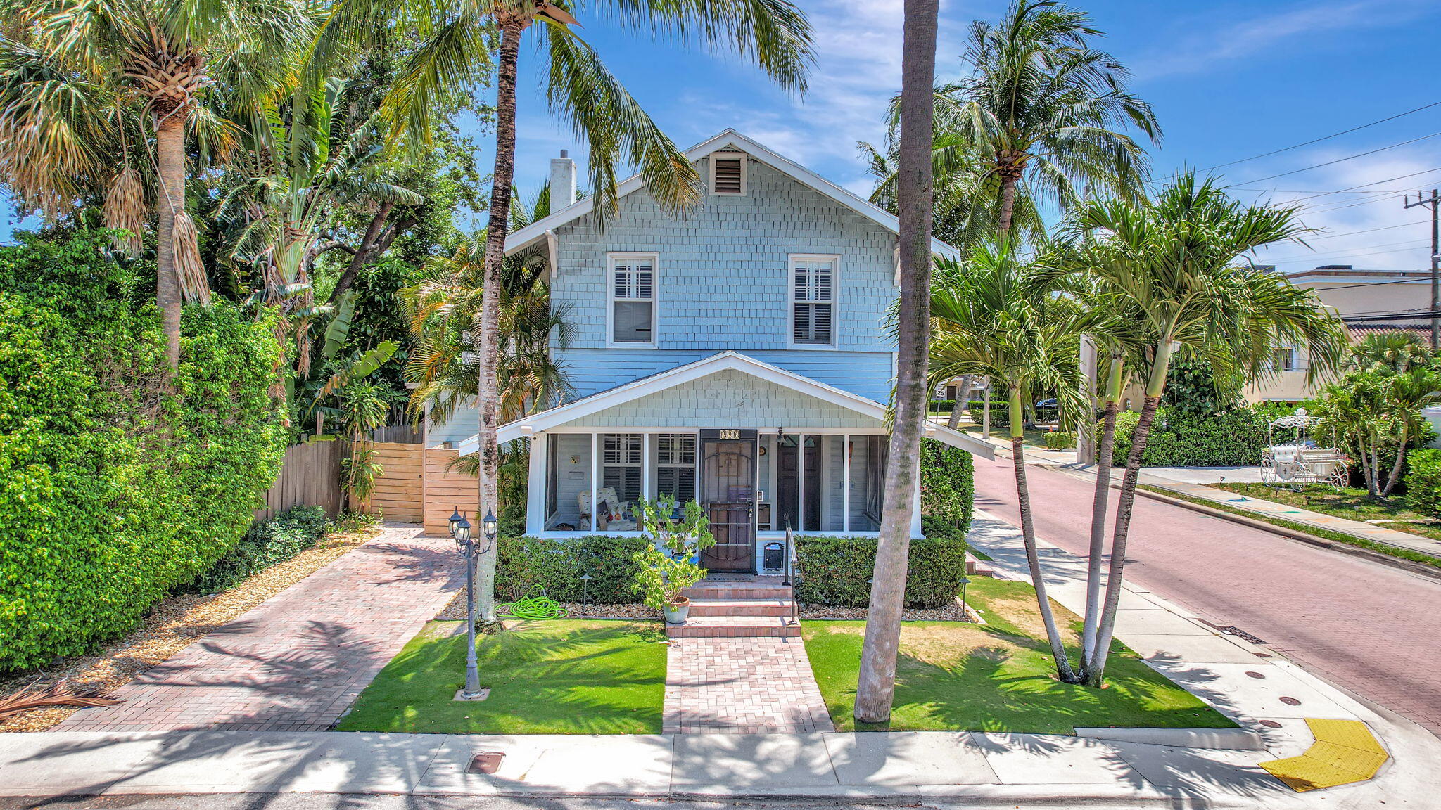 a front view of a house with a yard and potted plants