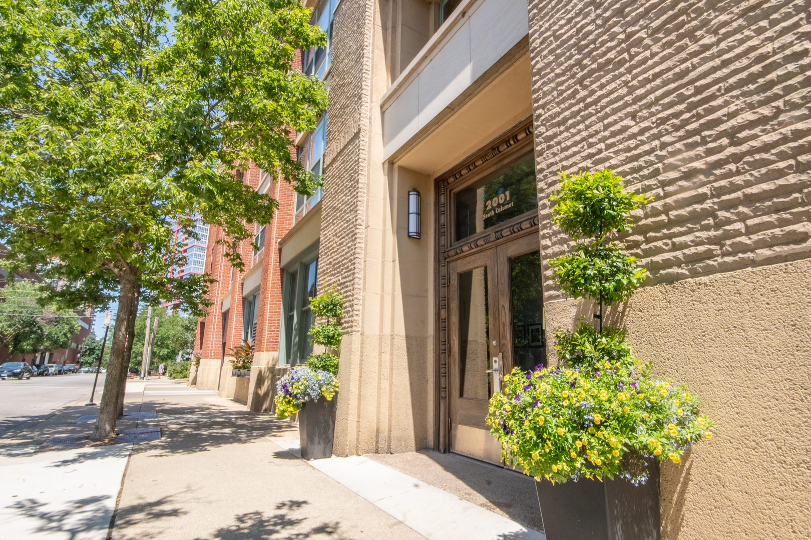 a view of a path along with brick wall and potted plants