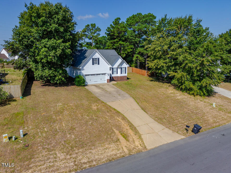 a view of a house with a yard and large tree