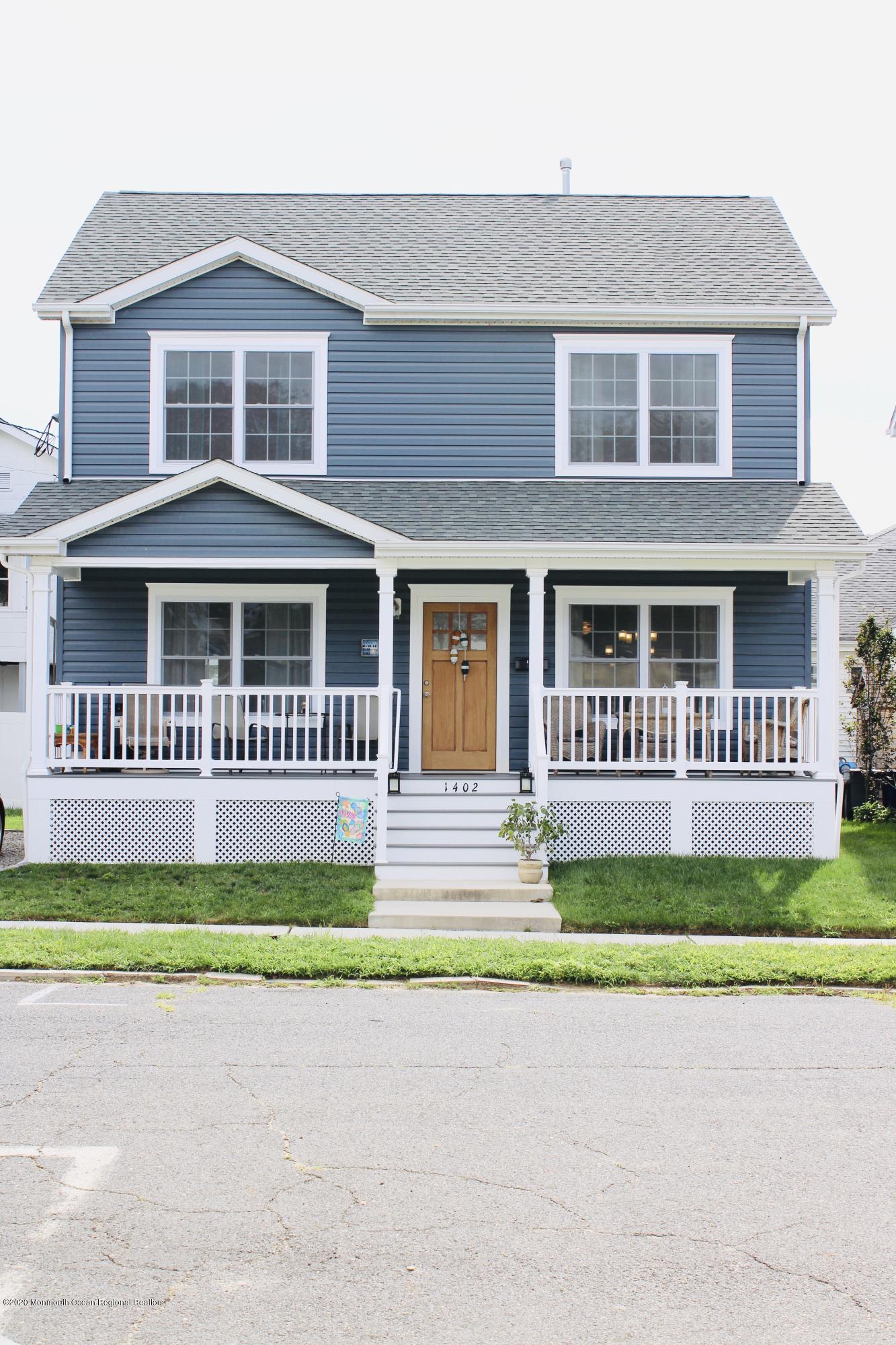 a front view of a house with a garden and trees