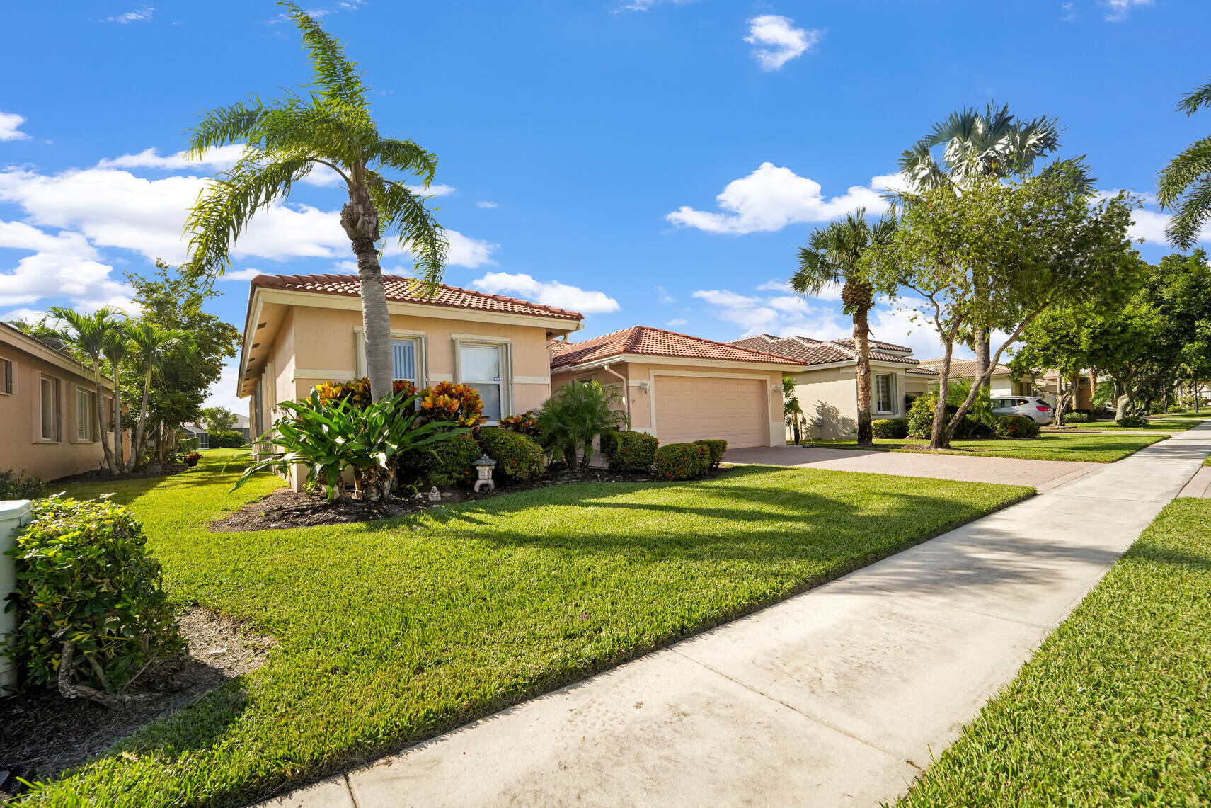 a front view of a house with a yard and potted plants