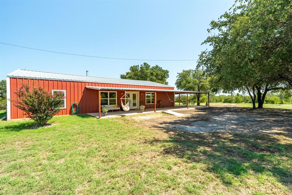 a view of a house with backyard and a patio