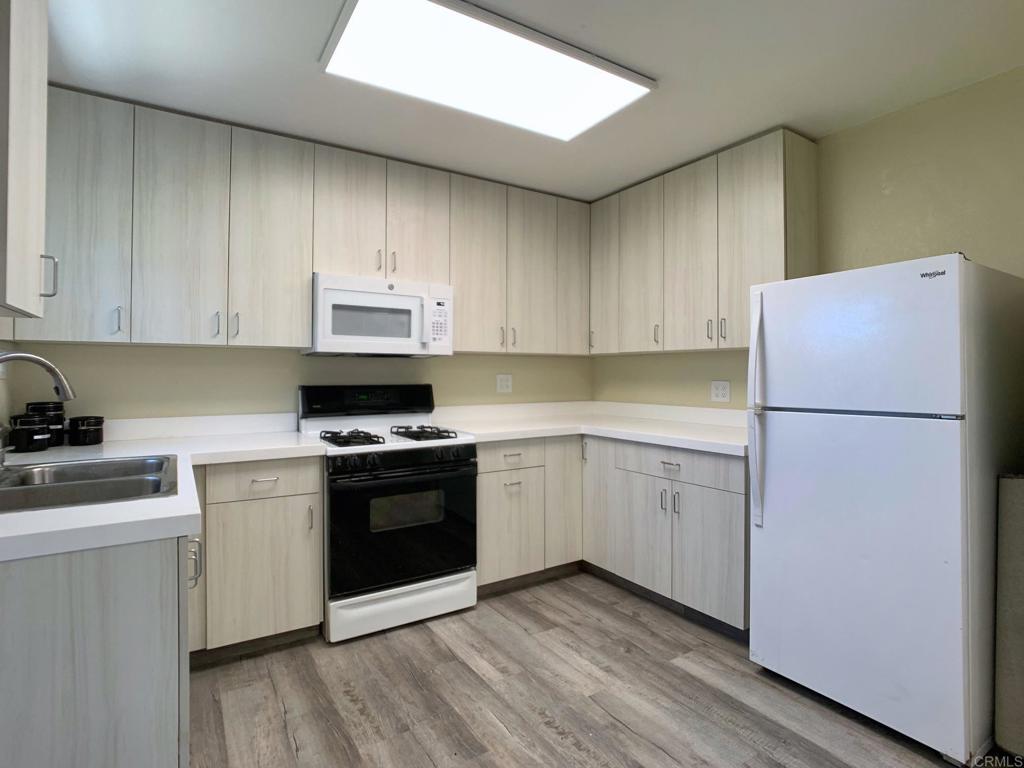 a kitchen with a refrigerator stove and white cabinets