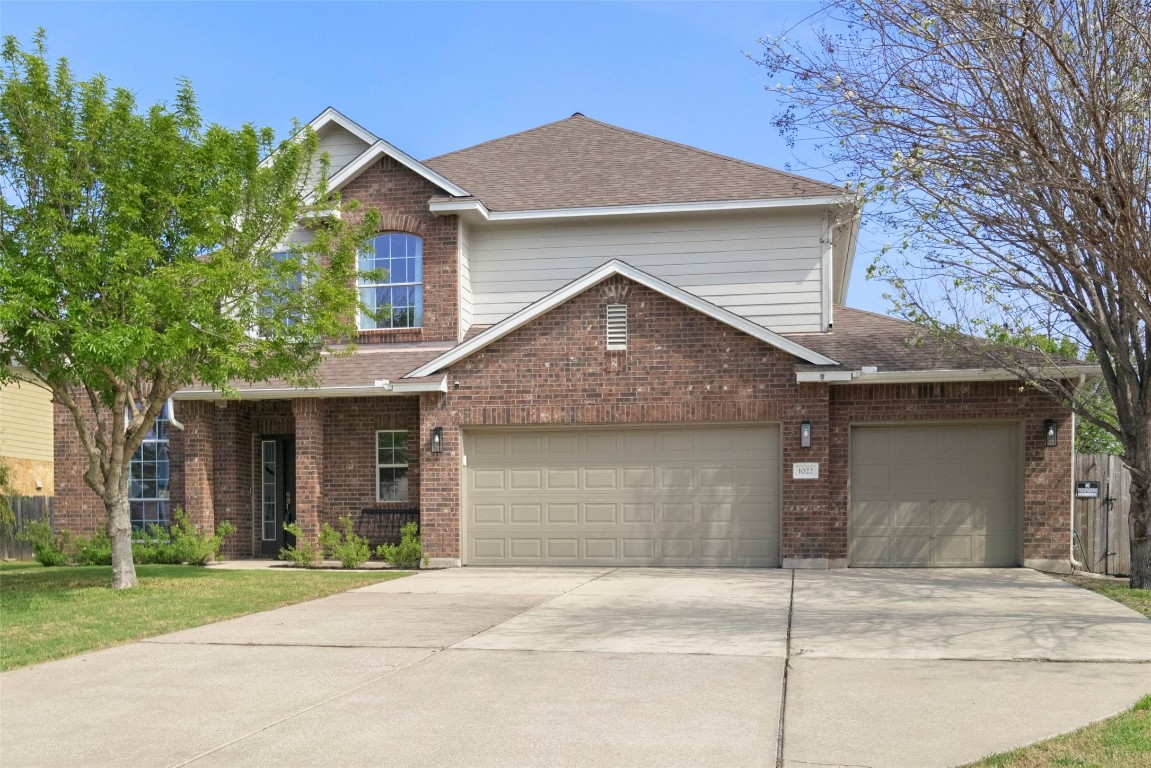 a front view of a house with a yard and garage