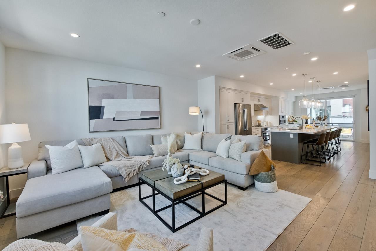 a living room with furniture and kitchen view