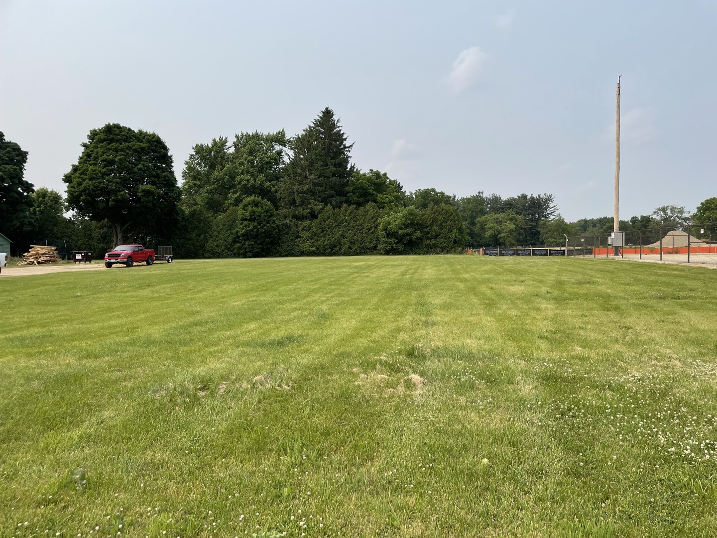 a view of a green field with trees in the background