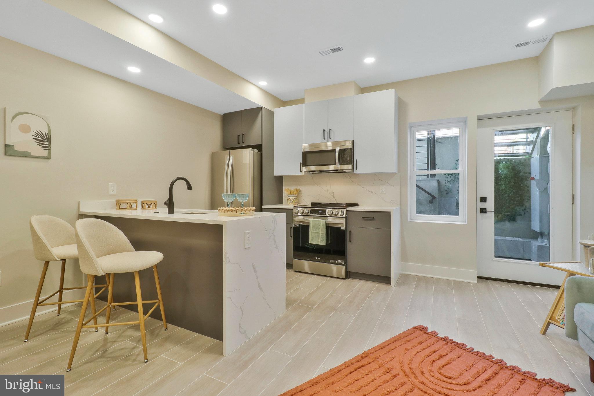 a kitchen with kitchen island stainless steel appliances a sink and a refrigerator