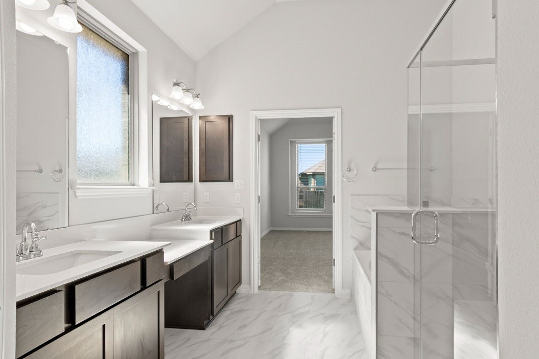 a bathroom with a double vanity sink a mirror and a bathtub